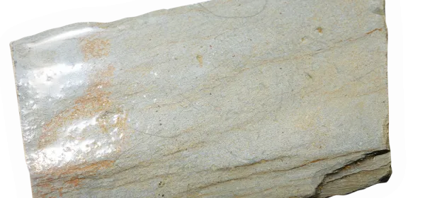 Killas rock sample featuring fine-grained, laminated textures in pale hues, representing meta-sedimentary country rock from Cornwall.