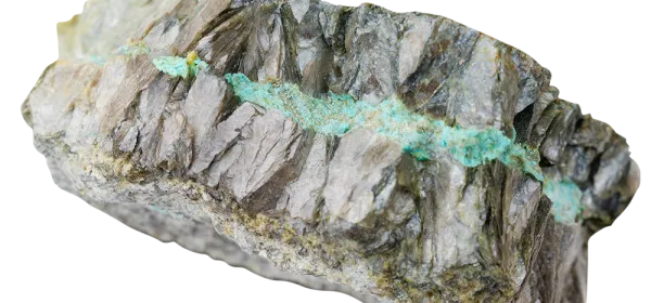 Close-up of lithium mica pegmatite showing green secondary copper minerals and coarse crystal structure on wet metallic surface.