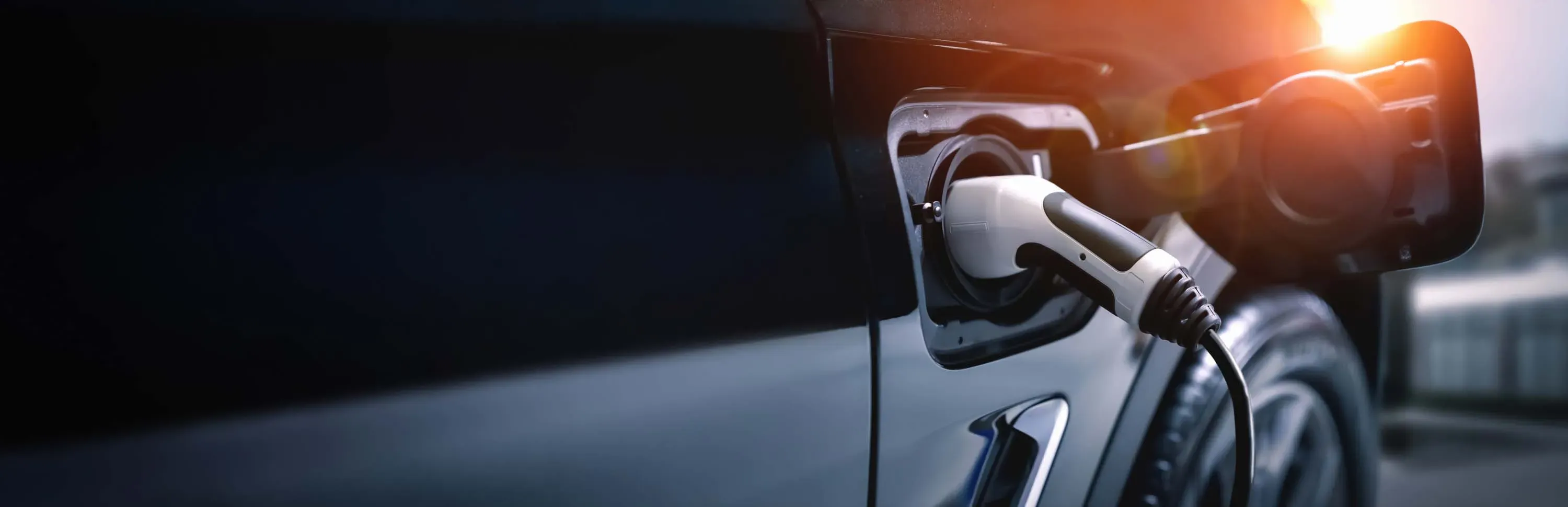 Close-up of electric vehicle being charged at sunset, symbolizing clean energy and lithium’s role in the energy transition.